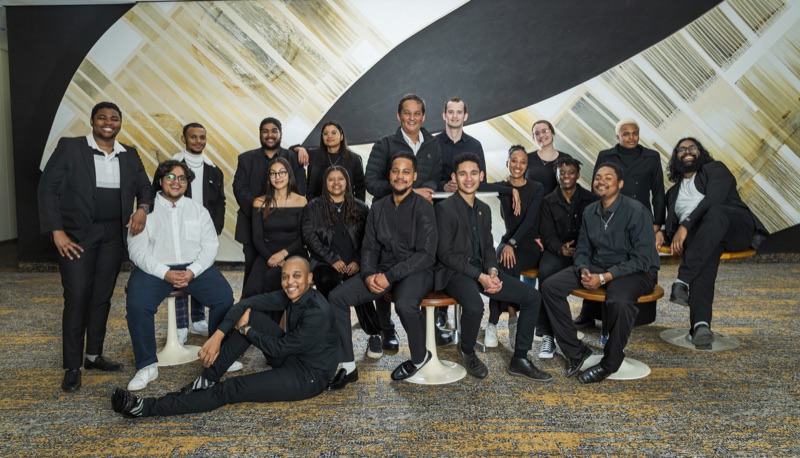 Ramon Alexander with a large jazz big band, the players gathered together in formal black for a group photograph.